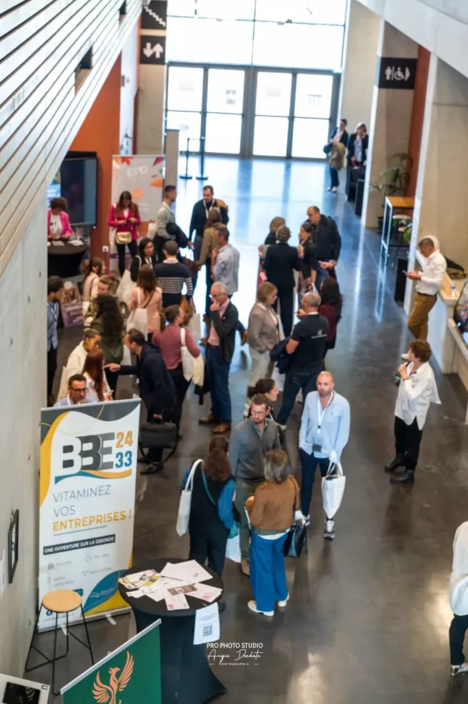 Les participants échangent dans le hall de l’Espace Étincelle, entre les kakémonos du BBE24-33 et des exposants